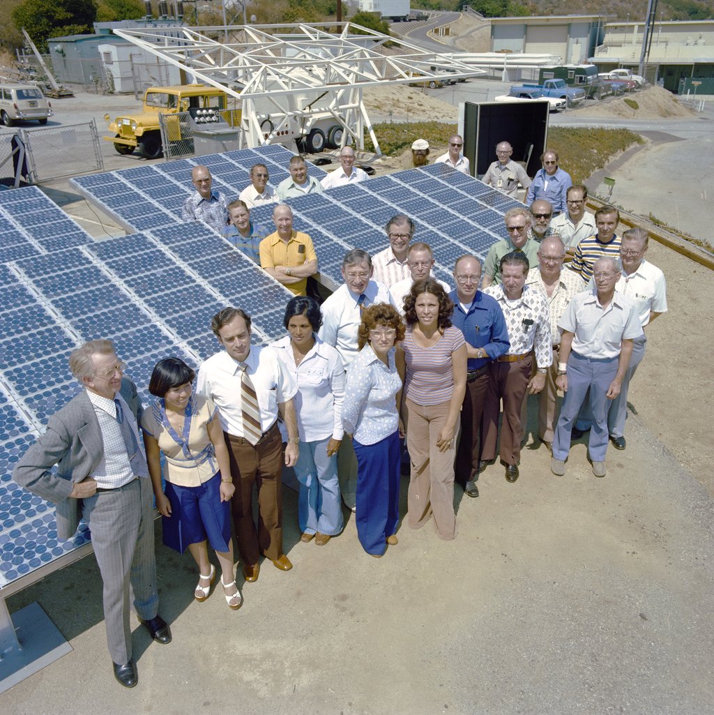 Group of people standing in front of a solar array