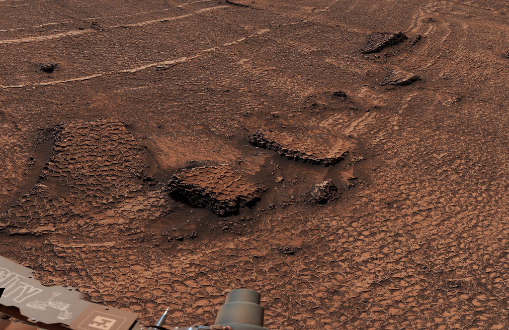 NASA’s Curiosity rover captures a rocky, reddish Martian landscape filled with polygonal fractures.