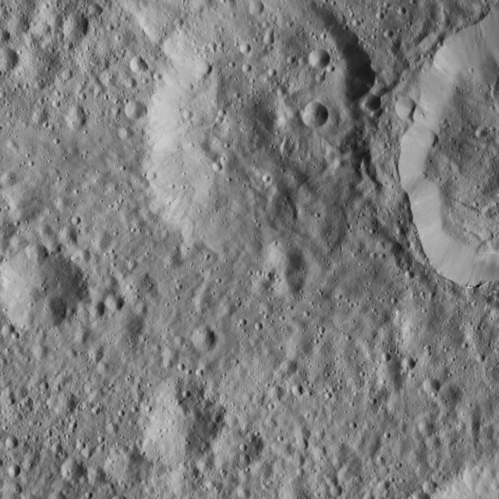 This scene from Ceres, captured by NASA's Dawn spacecraft, shows an older crater (at top center) that has been blanketed by impact ejecta from the younger crater to its right.